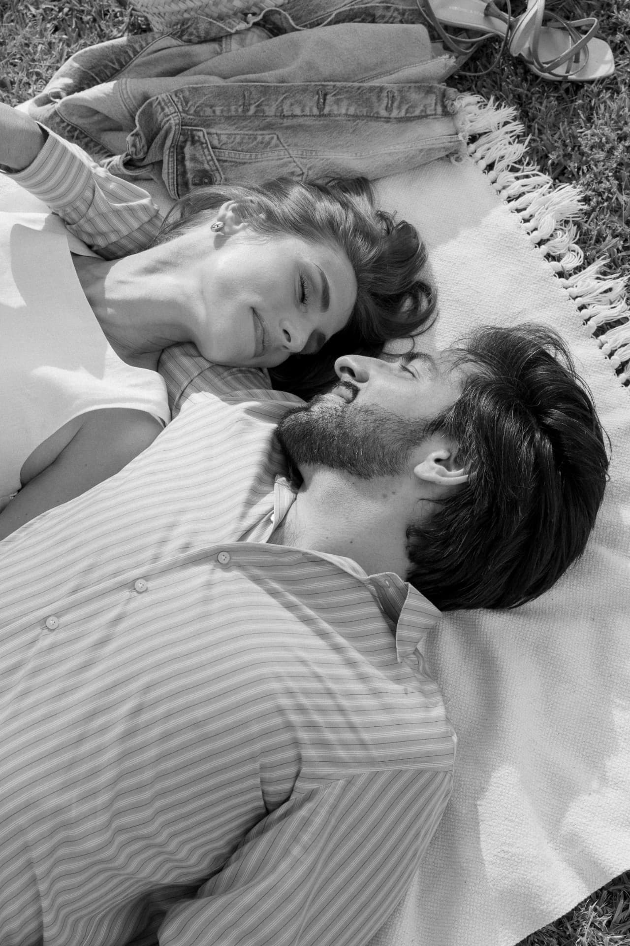 Black and white portrait of the couple resting head to head on a blanket