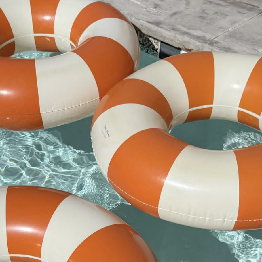 Orange and cream striped pool floats on the water