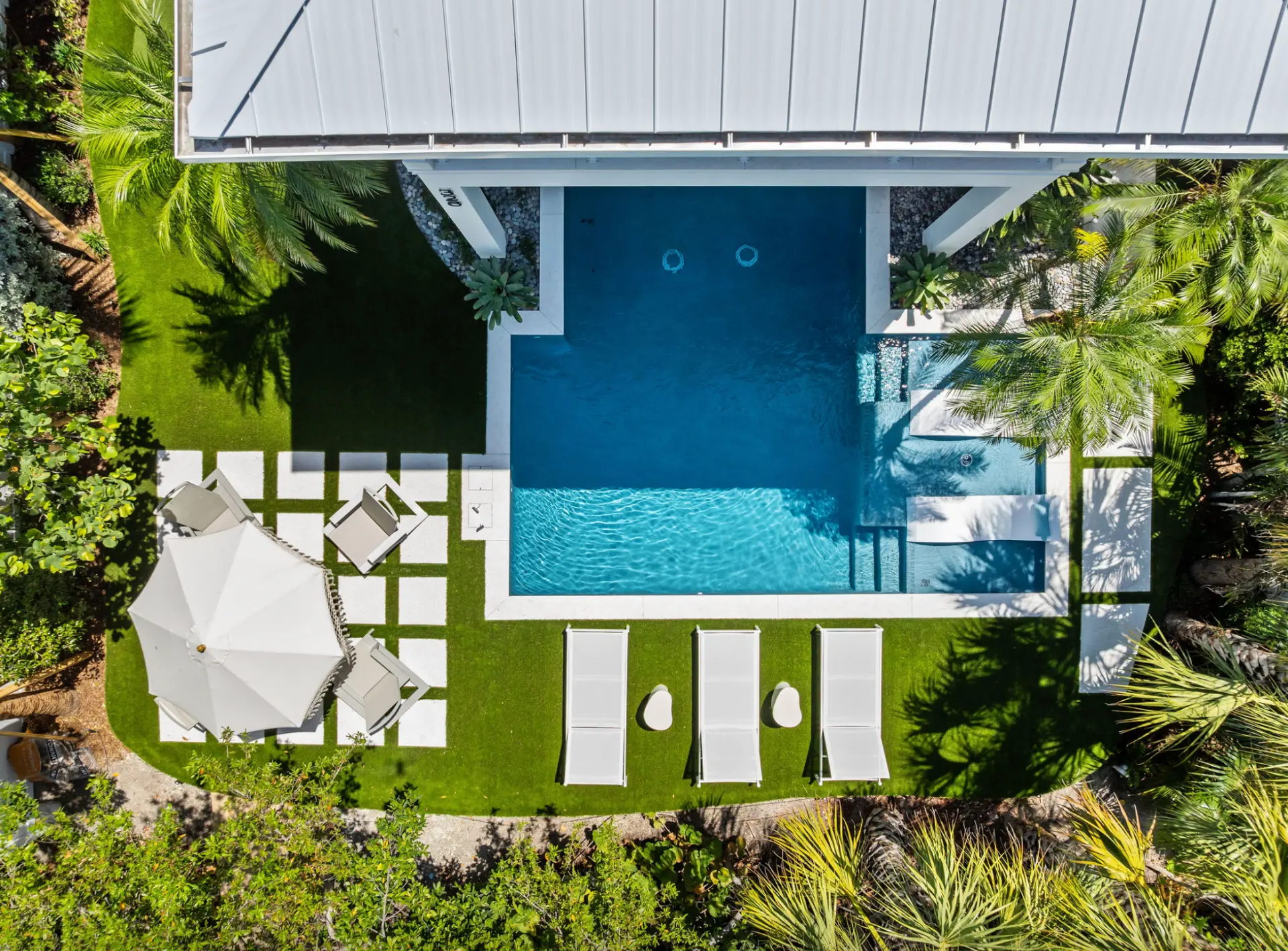 Aerial view of the pool, loungers and palms at the island house